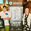 Photo of the Mayor and Mayoress and a representative of Srebrenica UK in front of a pull up banner which says Remembering Srebrenica