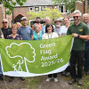 Group of people with Wirral's Mayor Brian Kenny holding a Green Flag
