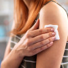 picture of woman's arm with cotton wool held over a vaccination site