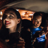Two girls in the back of a private hire taxi after a night out