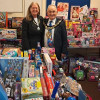 Photo of the Mayoress and Mayor surrounded by hundreds of gifts that were donated