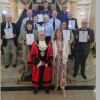 Photo of the mayor and Mayoress of Wirral on a grand staircase in Wallasey town hall with the recipients of the Wirral Award holding their certificates of appreciation