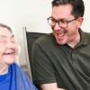 2 men smiling, one is elderly and the other is younger