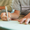 child writing in notebook