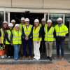 Councillors, traders and construction workers stand outside the former TJ Hughes unit that will become Birkenhead Market wearing high vis jackets and hard hats