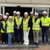 Councillors, traders and construction workers stand outside the former TJ Hughes unit that will become Birkenhead Market wearing high vis jackets and hard hats