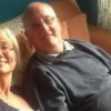 Man and woman sitting on the couch smiling at the camera