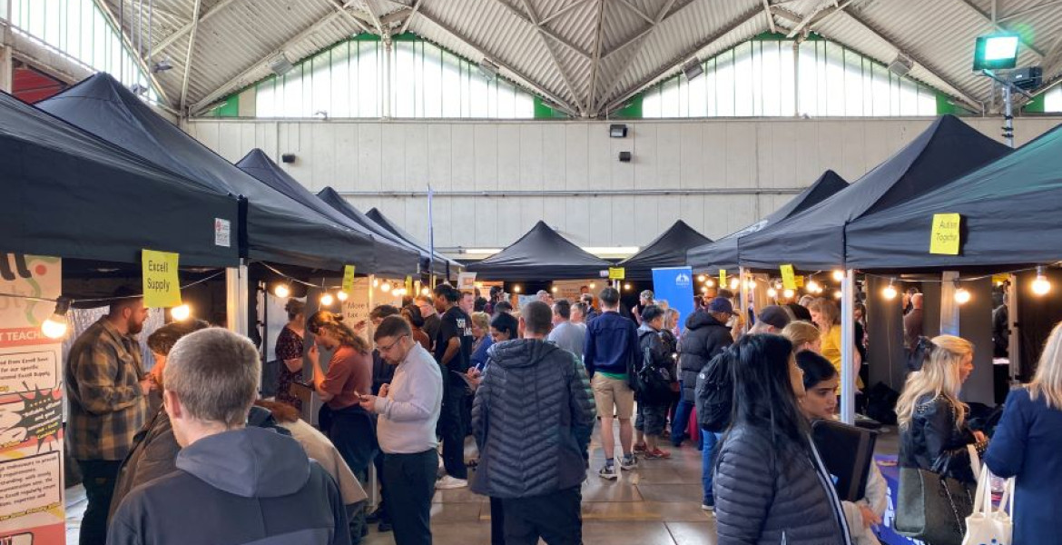 Lots of people shown browsing stalls at a jobs fair in Birkenhead Market