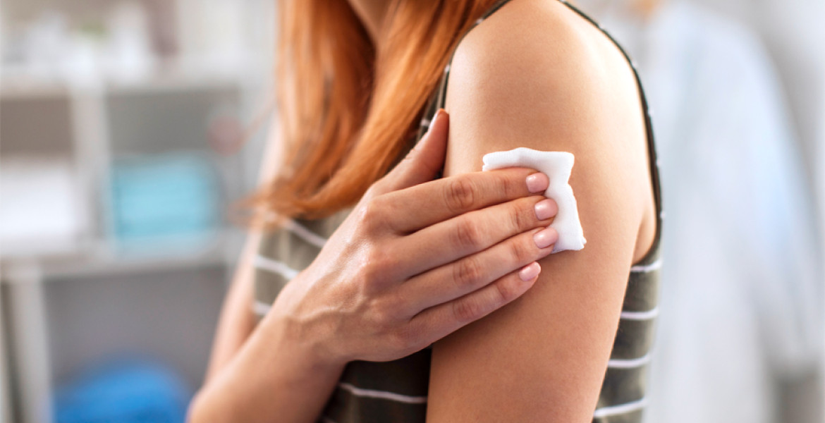 picture of woman's arm with cotton wool held over a vaccination site