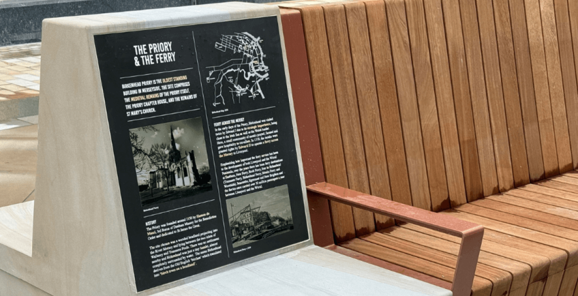 Close up of one of the stone and timber benches where you can see a plaque with information on about the priory and the ferry in Birkenhead