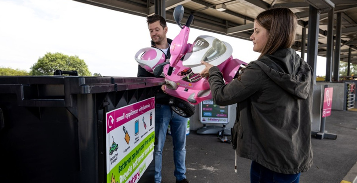 A stock image of a dad and daughter disposing of old toys at their local recycling centre