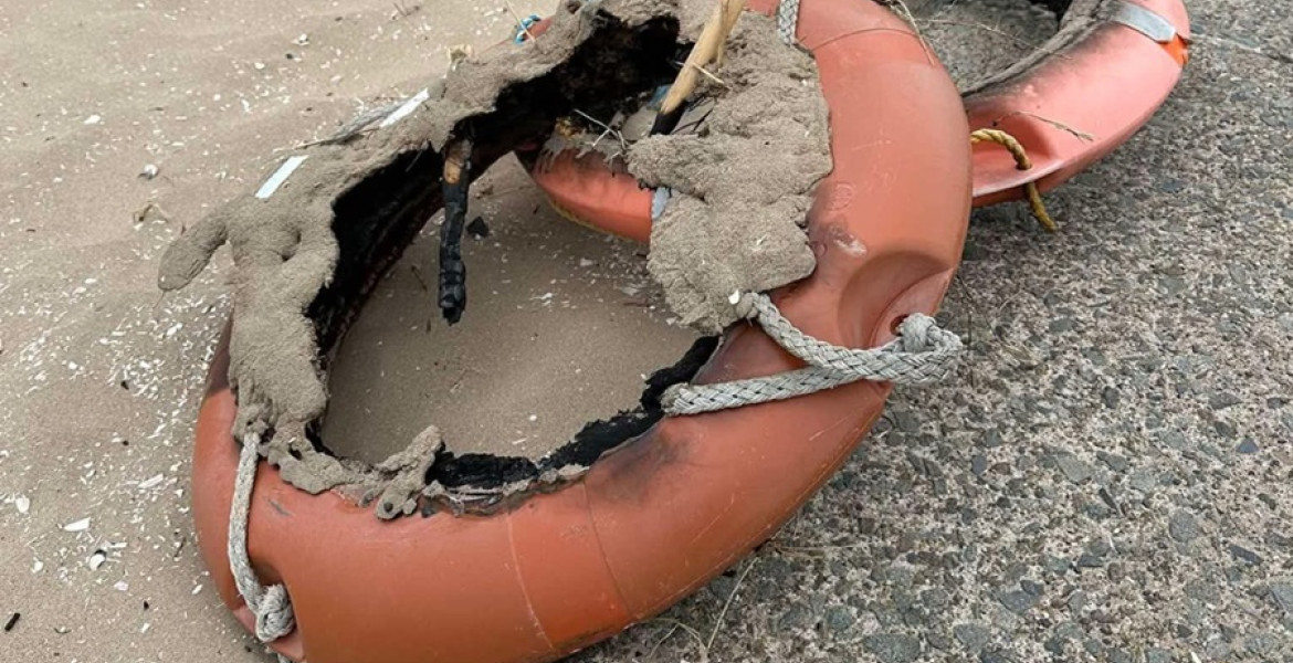 Fire-damaged life rings left behind on a beach in Wirral after being vandalised