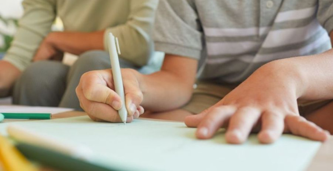 child writing in notebook