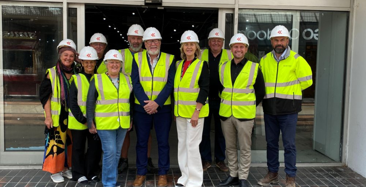Councillors, traders and construction workers stand outside the former TJ Hughes unit that will become Birkenhead Market wearing high vis jackets and hard hats