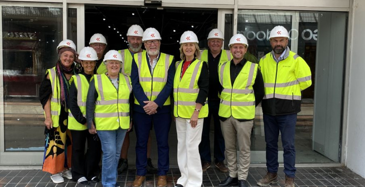 Councillors, traders and construction workers stand outside the former TJ Hughes unit that will become Birkenhead Market wearing high vis jackets and hard hats