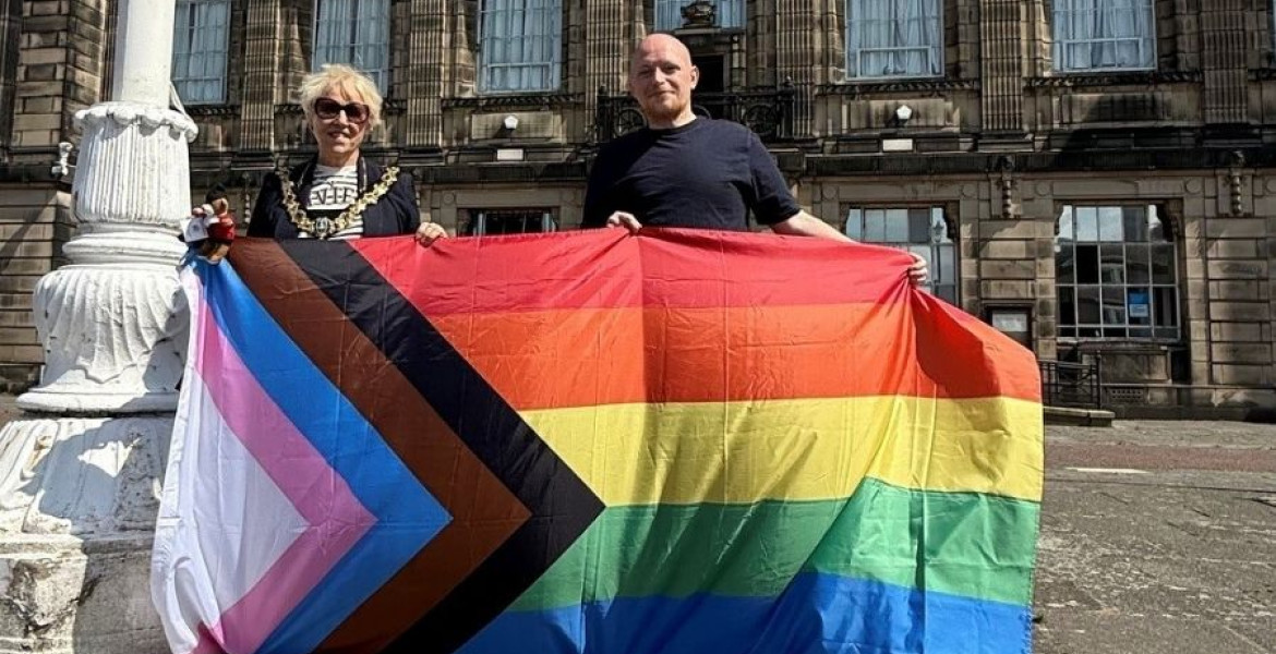 Photo of the Mayor of Wirral, Cllr Mary Jordan, and the Founder of Wirral Pride, Jamie Lee Carter, raising the Rainbow Flag at Wallasey Town Hall